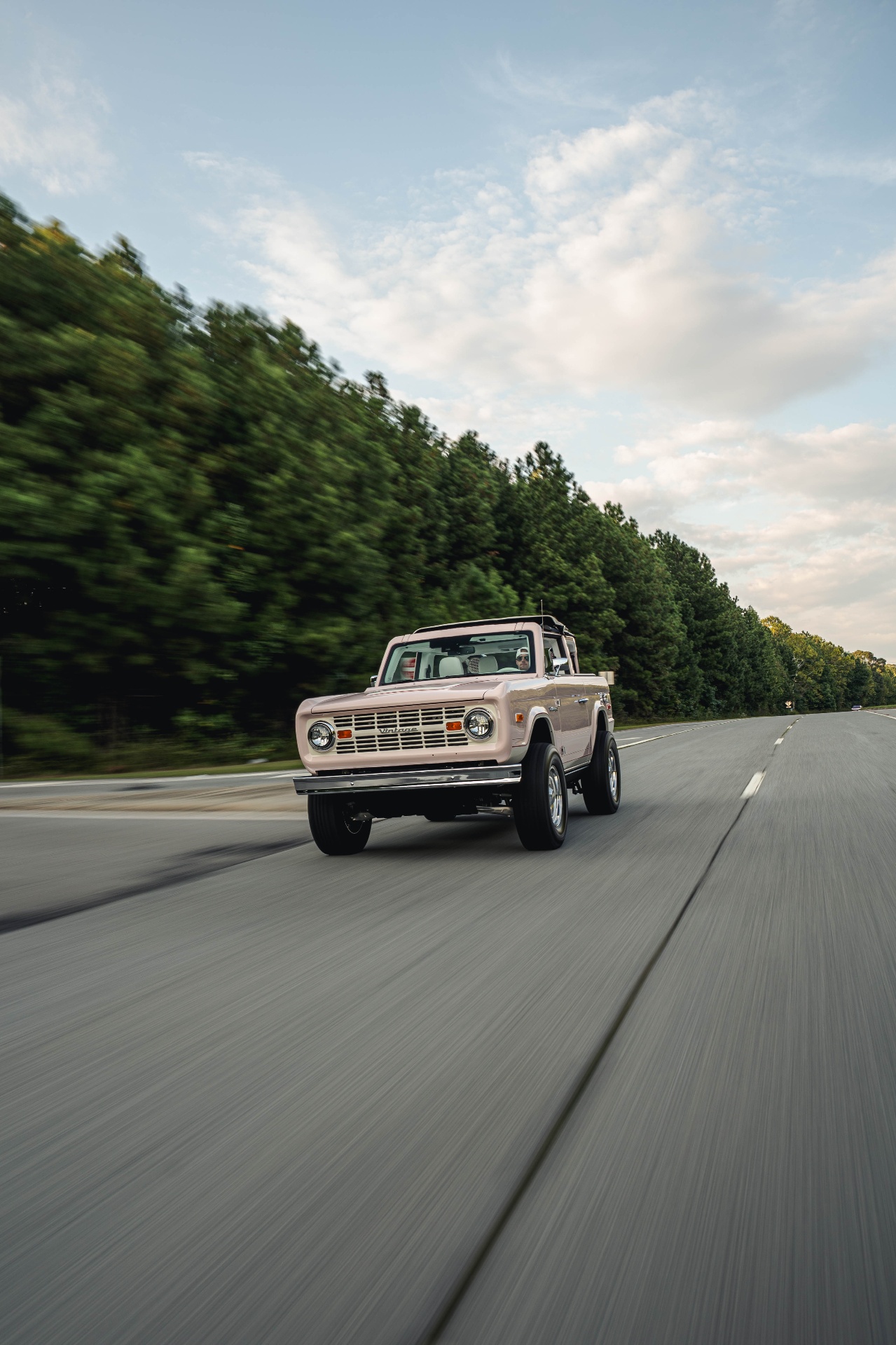 Blush pink Modern Classic driving on a scenic road